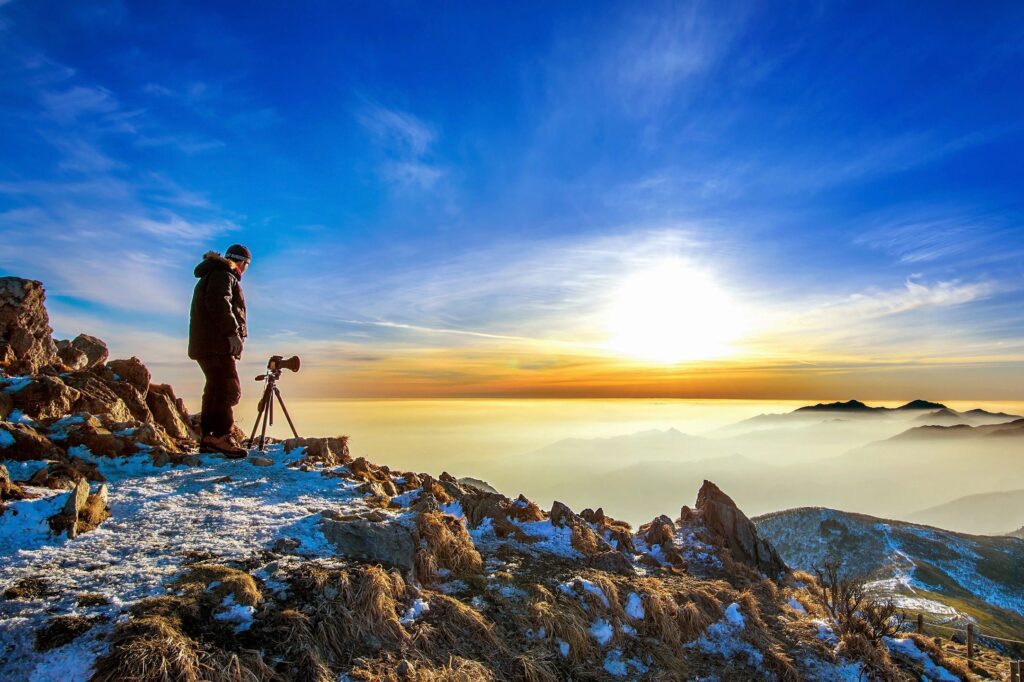 Man taking photo in nature showing resilience in the cold weather. 